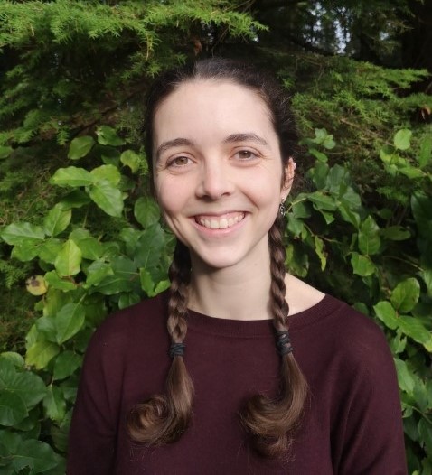 A photo of Brynn Williams, a woman with brown hair in braids smiling at the camera.